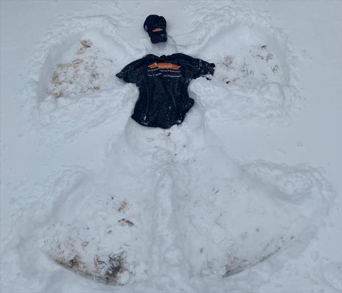 snow angel in the snow with a black hat and shirt